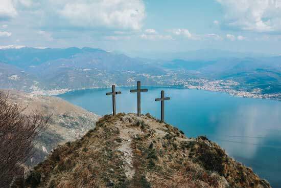 Three crosses on hill Jesus sacrifice Three crosses on a hill overlook a body of water surrounded by hills. They commemorate the sacrifice Jesus made to rescue anyone who would accept Him.