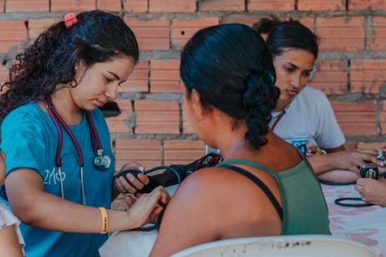 Woman taking blood pressure during health outreach effort A nurse taking the blood pressure of a woman