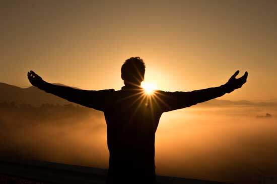 The silhouette of a man with his arms outstretched, rejoicing in his salvation