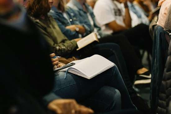 Group Learning in Church A group of people in church, listening and taking notes
