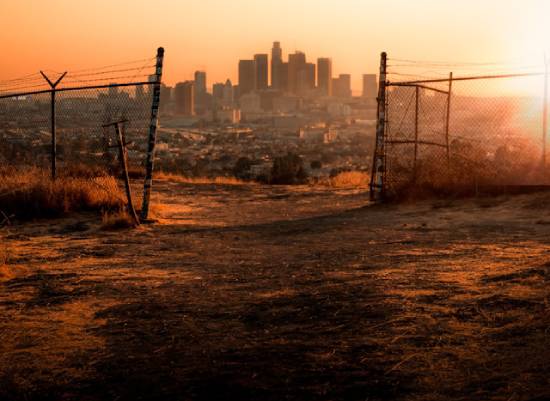An open gate leading to apocalyptic city ruins