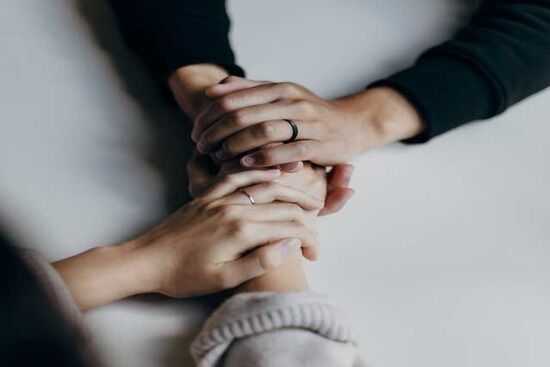 two sets of hands clasping for emotional support Support can come without words. Sometimes just being able to feel friends clasping your hands provides emotional support.