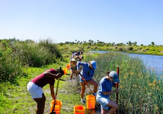 Working in Nature Students shovel alongside a creek.