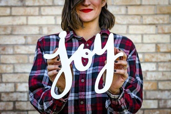 A woman uses her hands to frame the word "joy," one of the fruits of the Spirit.