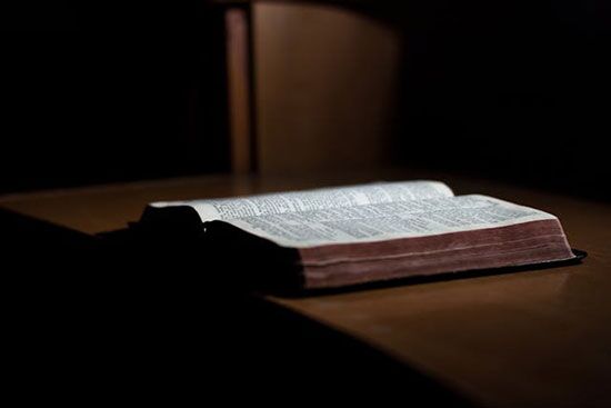 Open Bible on a wooden table An open Bible resting on a wooden desk