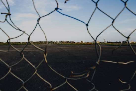 Hole in fence representing a broken barrier A chain link fence with a hole in it, symbolizing the barrier Jesus broke