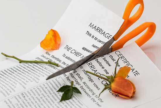Marriage certificate getting cut A marriage certificate being cut in half with scissors after a divorce