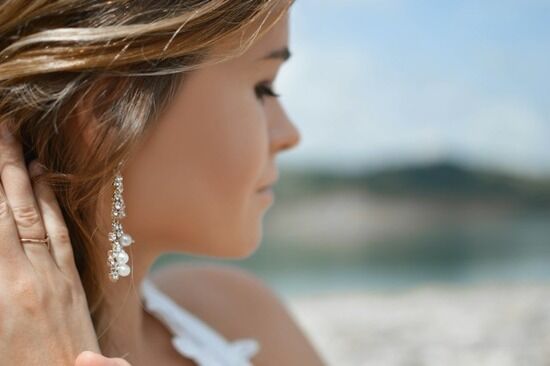 Woman Earring A woman pulling back her hair to reveal earrings as a sign of outward adornment