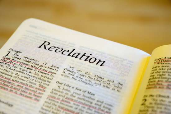 Book of Revelation Close-up of the first page of Revelation, focusing on the title with the verses blurring