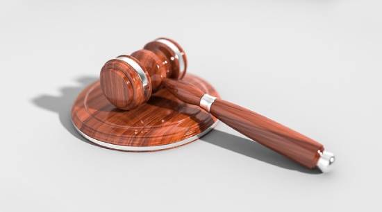 Brown wooden gavel on white surface A wooden gavel representing judgment