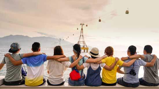 People sitting along seashore People sitting along the seashore with arms around each other, showing the love that Christians have for another
