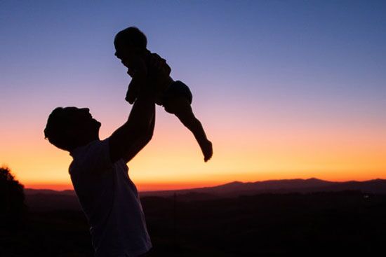 Father Holding Up Child Silhouette of a father holding his child as we learn how God cares for us more dearly than parents care for their children.