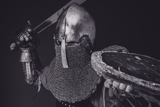 Soldier in battle armor with drawn sword Soldier with battle armor in posture of attack as we learn what does the armor of God mean to us in our practical daily life.