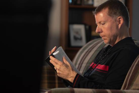 A man sits while reading his Bible, which provides insights into Israel's history and what we can learn from it.