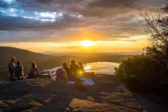 Families having vespers on a hill as the sun sets