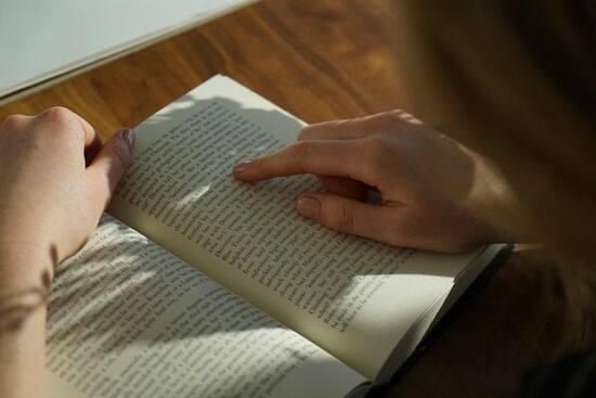 Reading book A person reading Ellen White's book to enrich Bible study