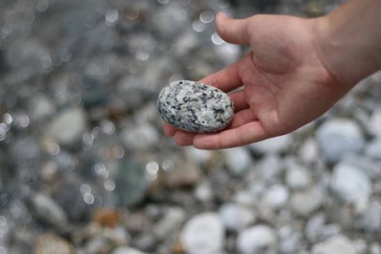 A hand picking up a stone