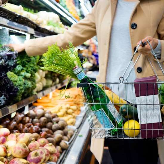 Woman buying groceries A woman carrying a basket as she shops for groceries