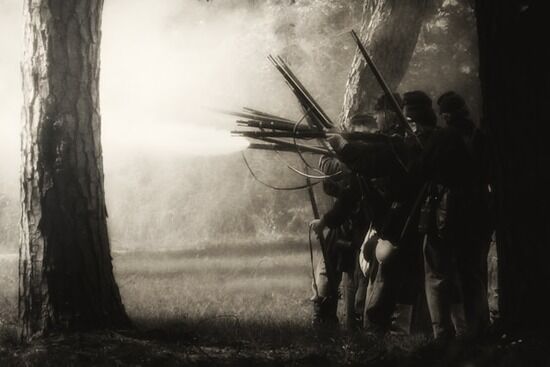 Civil War Soldiers A black and white photo of civil war soldiers lined up and firing at the enemy.