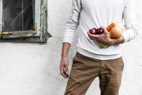 Healthy Man Holding Vegetables A man holds a variety of garden veggies, a foundational part of a healthy diet.
