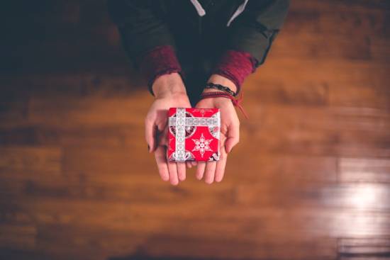 Hands holding a small gift Someone holds out a small, wrapped box, illustrating how salvation is offered to us as a gift.
