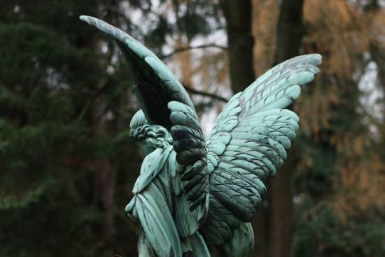 Statue of an angelic being A green angel statue in a forest, illustrating the Adventist belief that the devil is a created angelic being.