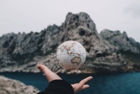 Hand tossing small globe into the air A hand tosses a small globe into the air like a ball. This illustrates how Satan views this world---something he can toy with.