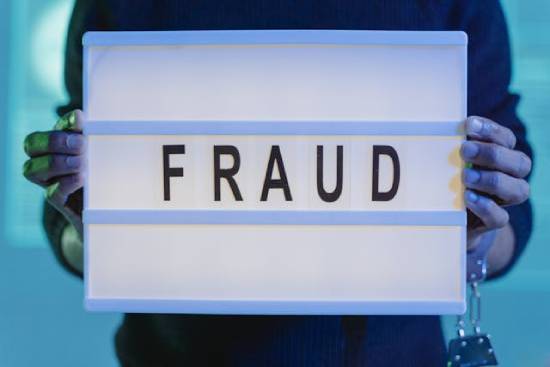 Sign that reads "fraud" Someone holds up a sign that says,