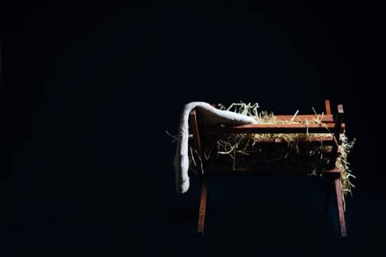 Manger with hay where baby Jesus was laid A manger's feeding trough with hay, reminding us of how Jesus's birth was a fulfillment of prophecy.