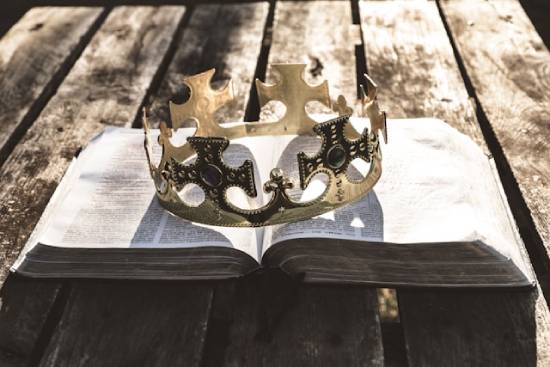 Open Bible with a crown sitting on top of it A king's crown resting on top of an open Bible