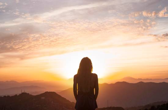 Woman looking at sunset contemplating life after death A woman watches the sunset from a mountaintop while contemplating the truth about life after death—something beautiful and reassuring when we understand what the Bible says.