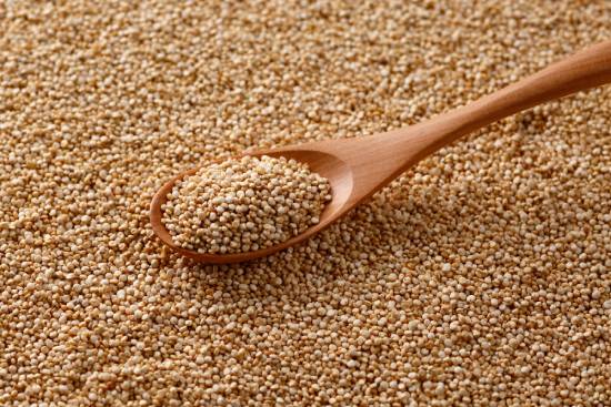 A spoon scooping up mustard seeds.