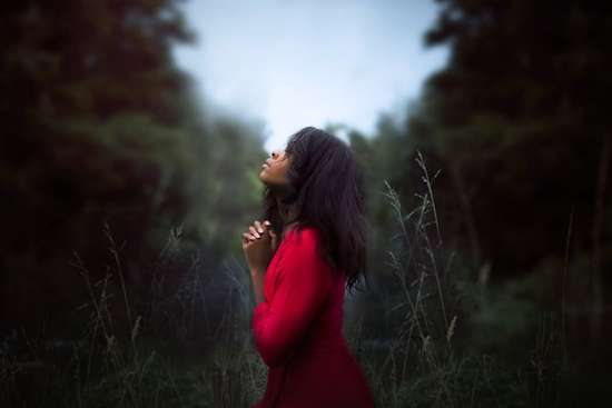 Woman praying in nature as we learn the importance of private prayers and time alone with God to pour our hearts to Him