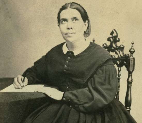 A photo of Ellen White sitting with a pen and paper at a table. Her writings helped shape the Adventist perspective on health.