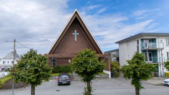 An A-frame Adventist church with a cross on the front