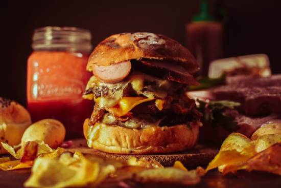 A massive burger with potato chips illustrates the unhealthy choices and lack of self-control.