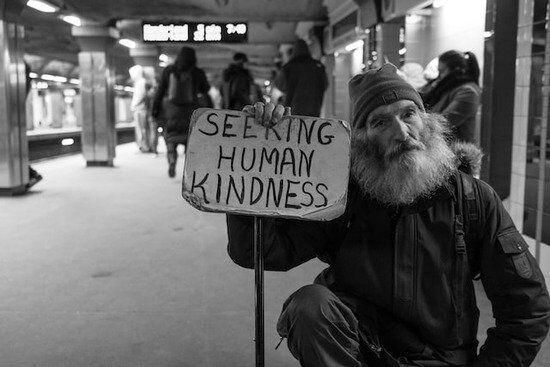 Kindness A homeless man holds a sign that says "Seeking human kindness," highlighting kindness as one of the fruits of the Spirit.