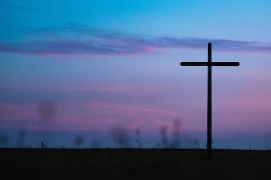 A woman's hand taking notes as she studies the Bible