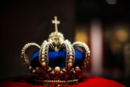 A blue royal crown sits on top of a red pillow, representing that the best will have earthly rulership and authority.