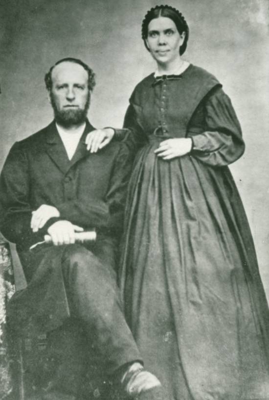 Black and white portrait of James and Ellen G. White A black-and-white photograph shows James White sitting in a chair while his wife, Ellen White, stands by his side.