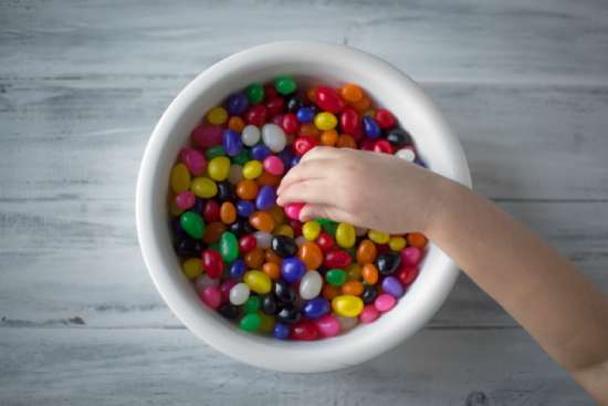 Child Hand Candy Bowl A child's hand reaching into a bowl of jelly beans