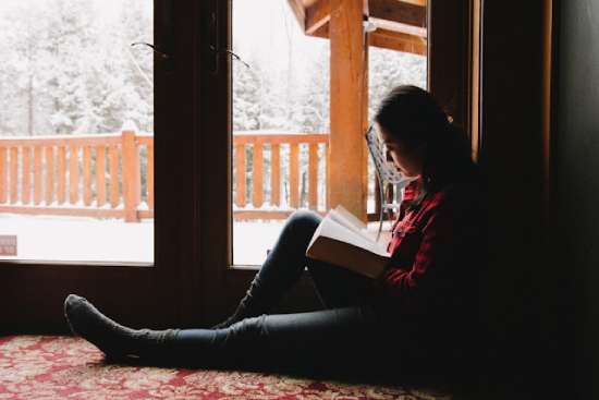 Woman Sitting on Floor Reading her Bible A woman sitting on the floor studying her Bible