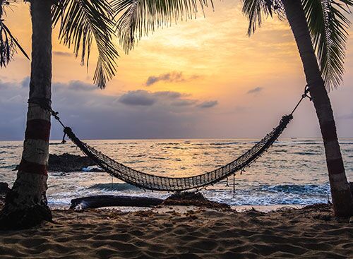 hammock-sunset-small A hammock on a beach at sunset for enjoying a day of rest