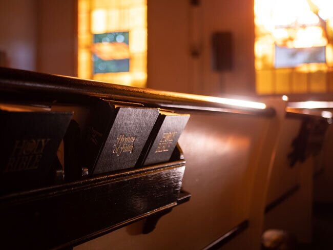 Two Hymnals in Pew The latest edition of Seventh-Day Adventist Hymnal behind the pew, published by Review & Herald in 1985