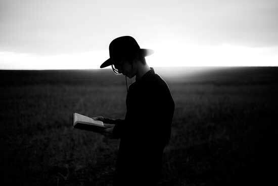 Man Reading Bible With Hat A Millerite reads the Bible as he walks through an open field.