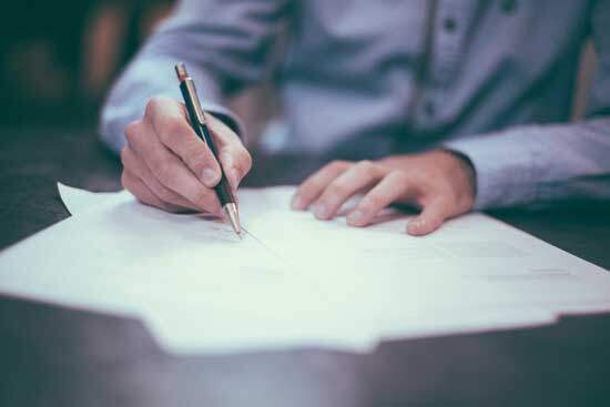 Man Writing A man writes with pen and paper.