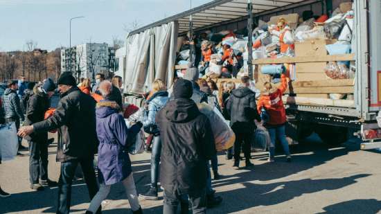 People serving relief materials People stand in line to bring donations to a relief truck.