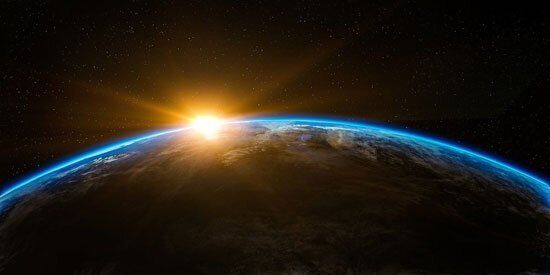 Earth A view from space of the sun peaking over the earth