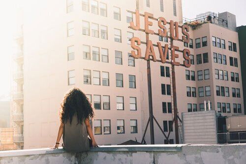 Girl sitting on Terrace looking at Signboard that says Jesus Saves Girl sitting on the terrace looking at the signboard which says Jesus Saves showing how Adventists value evangelism