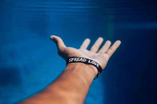 An Outstretched Hand An outstretched hand with a bracelet that says, Spread Love